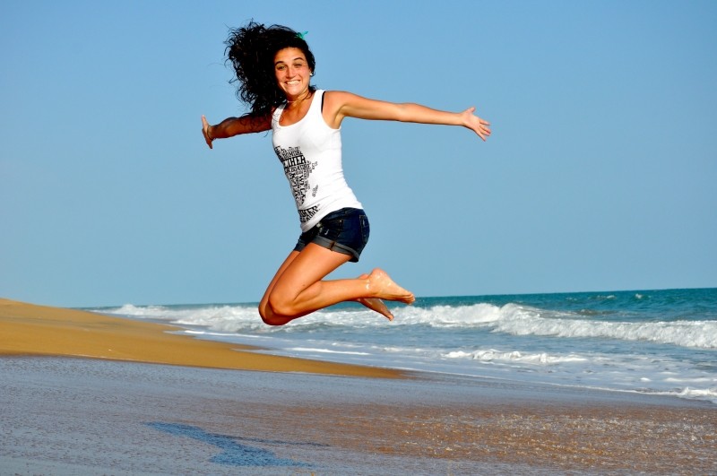 happy-young-woman-jumping-on-beach